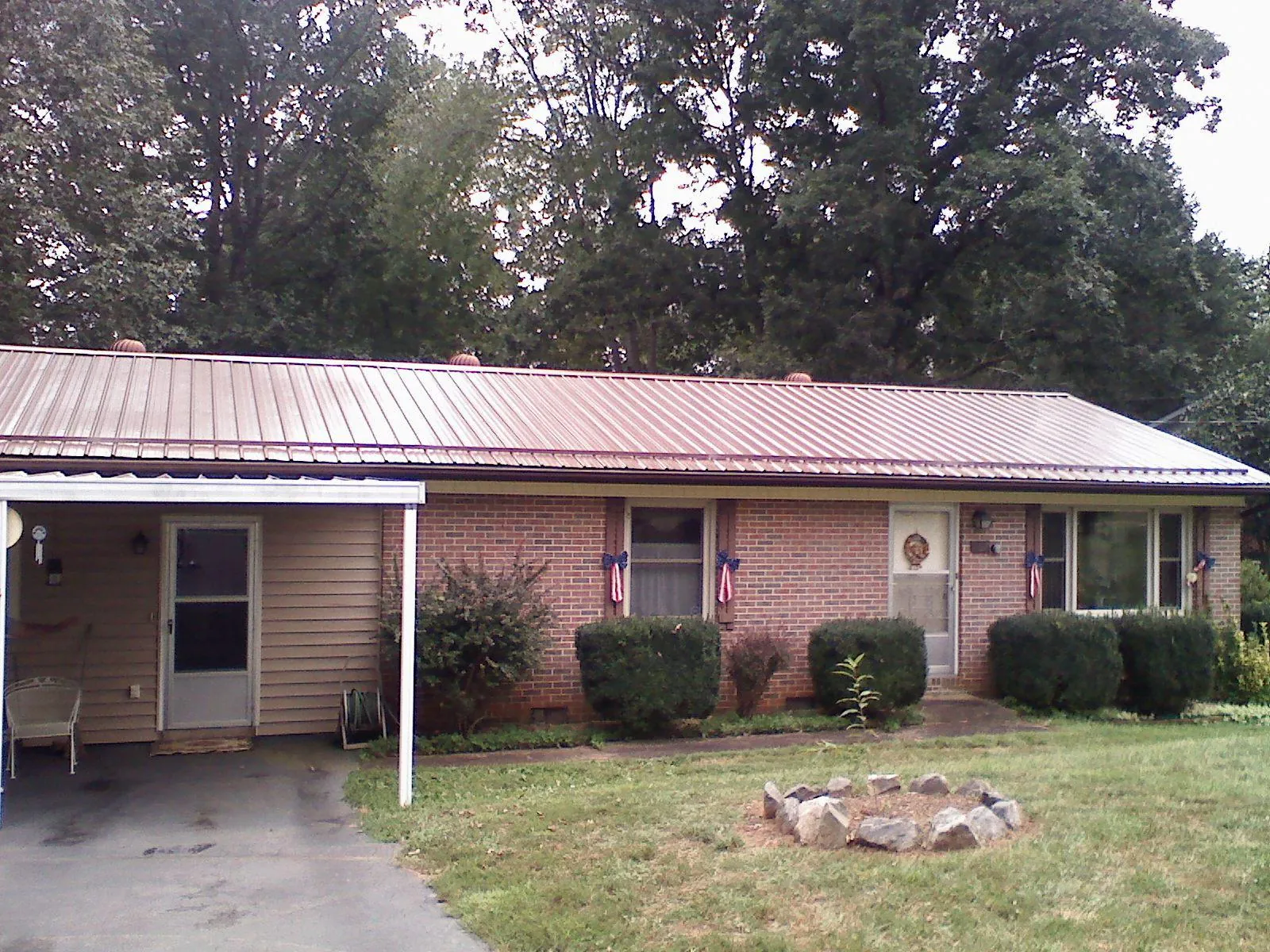Bronze metal roof and carport on a brick ranch home — Roof Repair work by our crew in Waverly